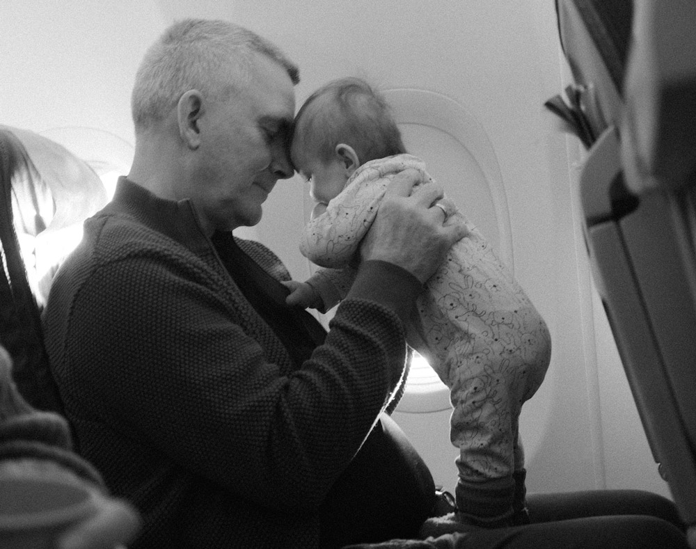 Father holding baby on plane